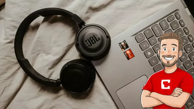 Sluchátka položená na klávesnici laptopu