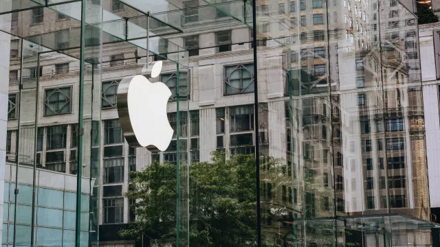 Logo Apple na prosklené budově.