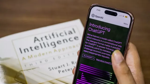 ChatGPT na displeji smartphonu a v pozadí na displeji laptopu