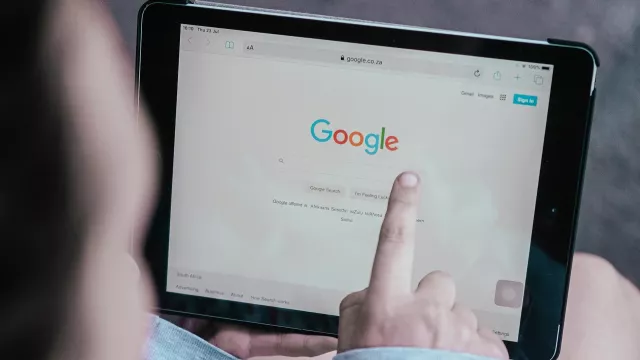 Uživatel ukazuje prstem na prohlížeč Chrome na svém tabletu