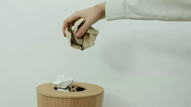 Uživatelka odhazuje papír do koše.