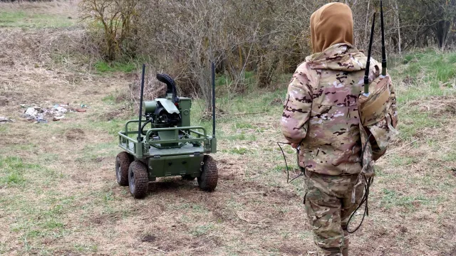 Voják testuje pozemní dron v terénu.