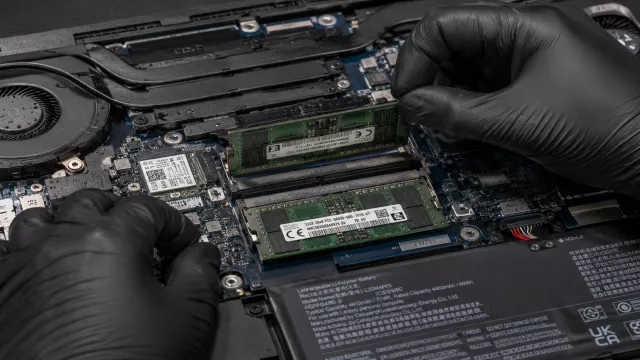 Technik vyjímá modul RAM z otevřeného notebooku.